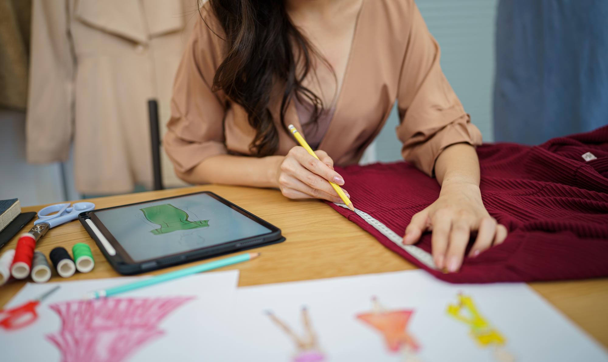 Instructor guiding student over hand embroidery